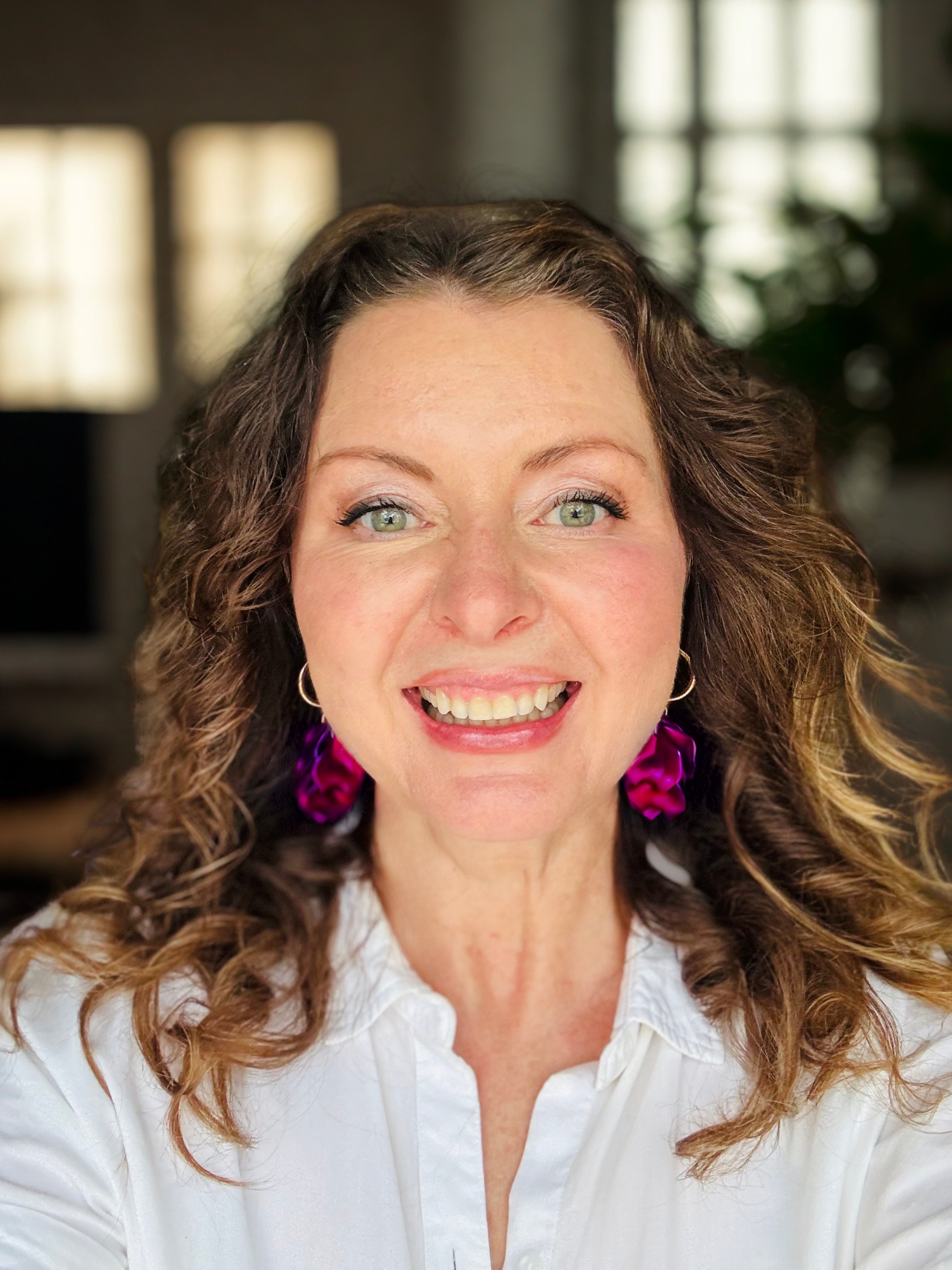 Melissa Runacres, trauma-informed money mindset coach for creative entrepreneurs, smiling and standing indoors.